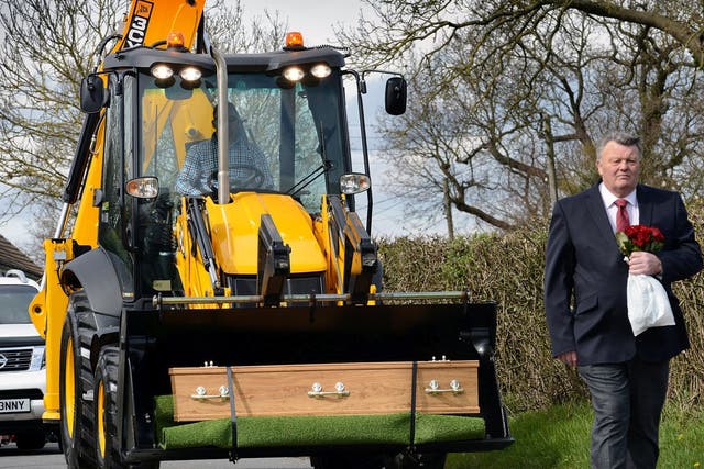 Geoffrey Durham's coffin was loaded onto the bright yellow earth mover before being driven to his final resting place.