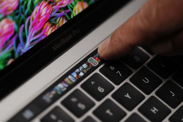 An Apple employee points to the Touch Bar on a new Apple MacBook Pro laptop during a product launch event