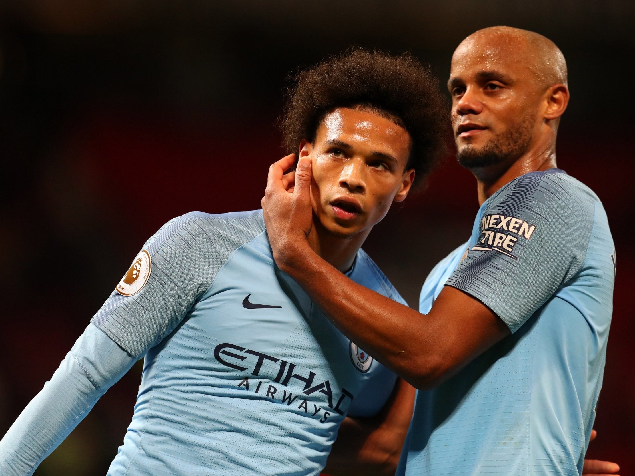 Vincent Kompany of Manchester City celebrates with teammate Leroy Sane