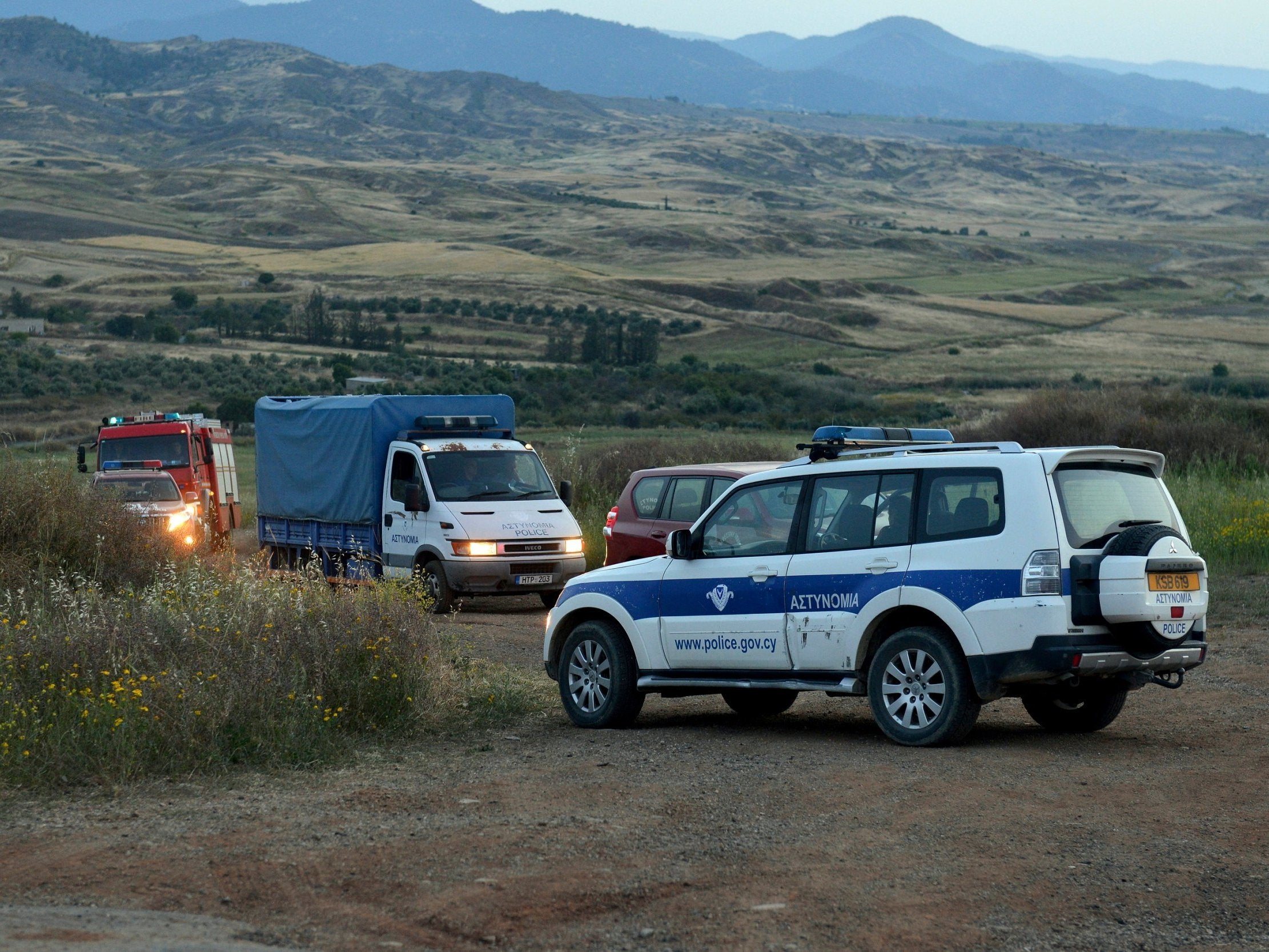 A police truck (rear left) carries a body found after investigators and police officers searched a field outside Orounta village, near the capital Nicosia, in Cyprus, on 25 April 2019.