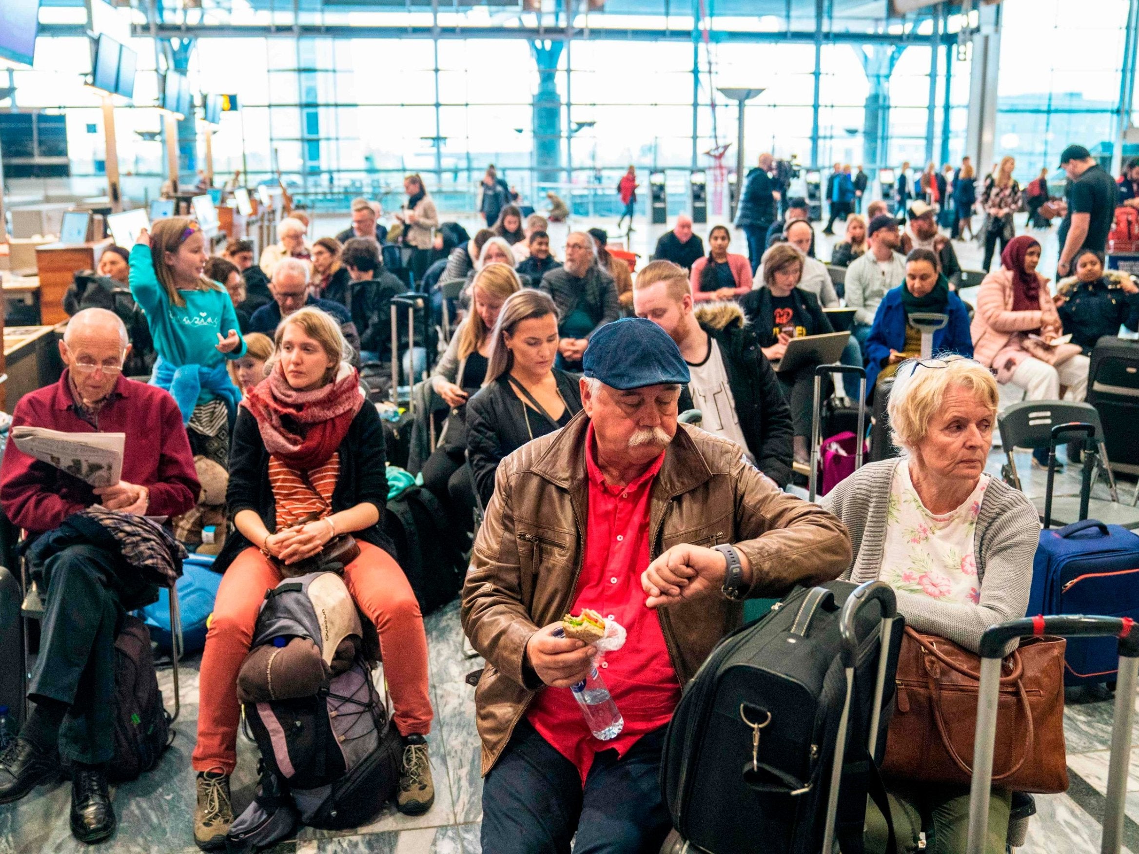 Travellers wait at Gardamoen Airport in Oslo, Norway