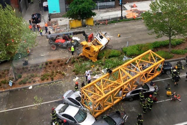 Fire and police crew members work to clear the scene where a construction crane fell from a building on Google's new Seattle campus crashing down onto one of the city's busiest streets and killing four people om 27 April 2019.