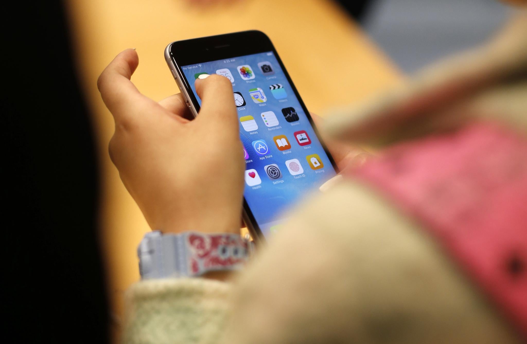 A child holds an Apple iPhone 6S at an Apple store on Chicago's Magnificent Mile in Chicago