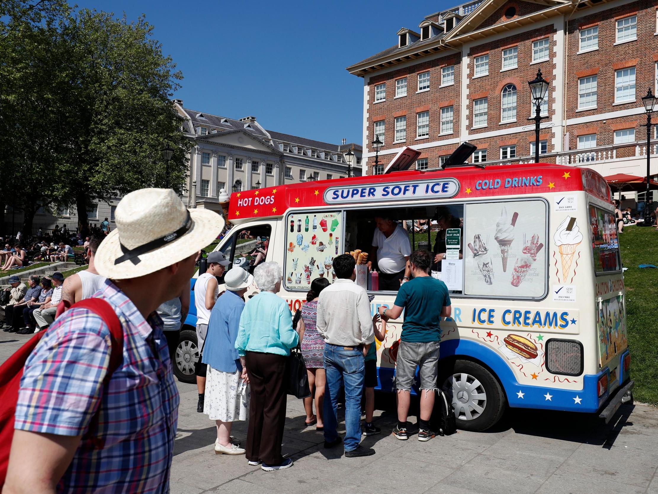 People queue at an ice cream van as they soak up the sun in Richmond, south west London