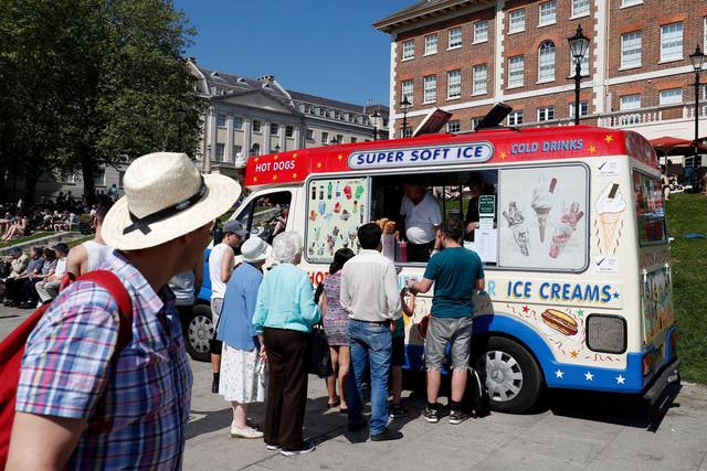 People queue at an ice cream van as they soak up the sun in Richmond, south west London