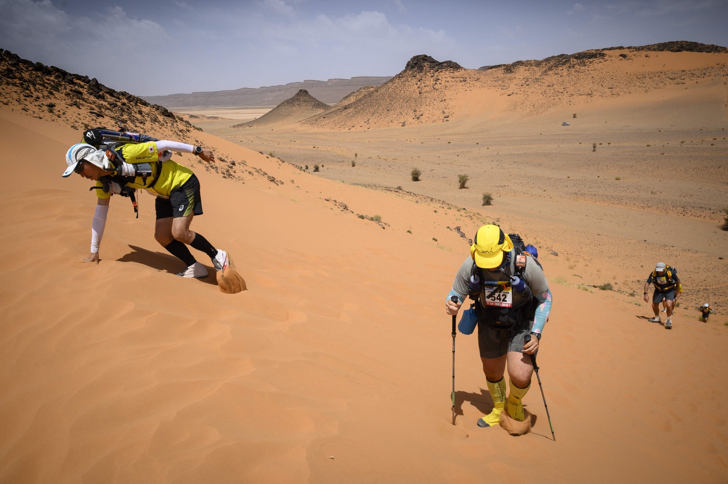 Runners climb up dunes in the Marathon des Sables