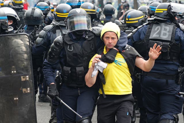 A French anti-riot policeman arrests a protester during clashes on the sidelines of the annual May Day rally in Paris