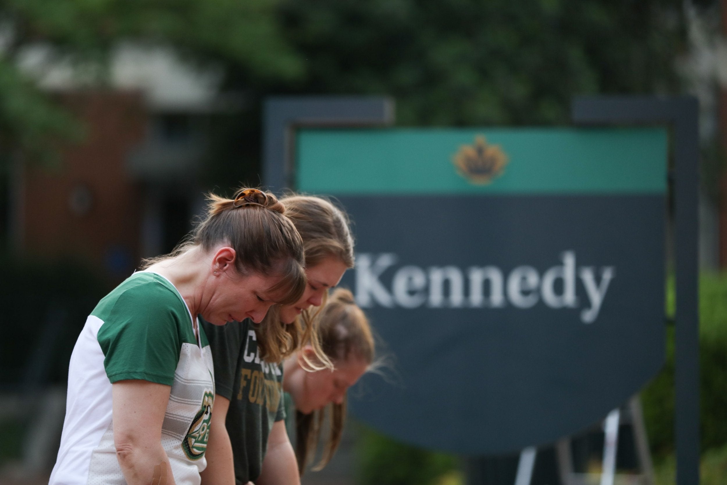 Students kneel at entrance of the University of North Carolina-Charlotte to pray for victims of the shooting