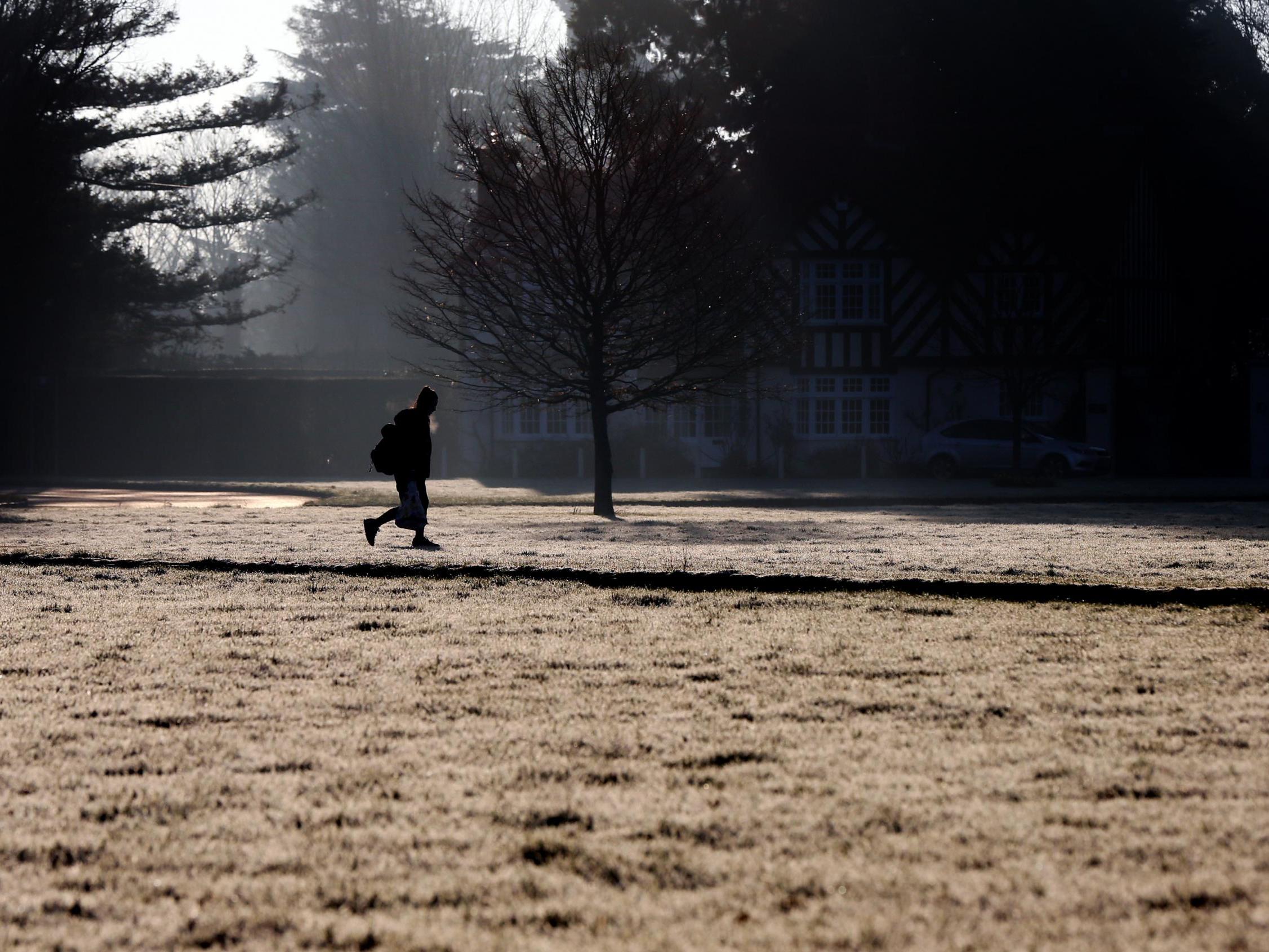 A schoolgirl makes her way through Holyport Green, Holyport, Berkshire as frost covers the ground in February 2019.