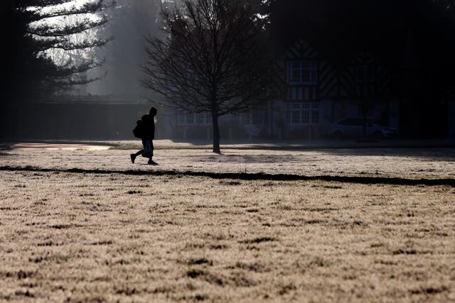 A schoolgirl makes her way through Holyport Green, Holyport, Berkshire as frost covers the ground in February 2019.