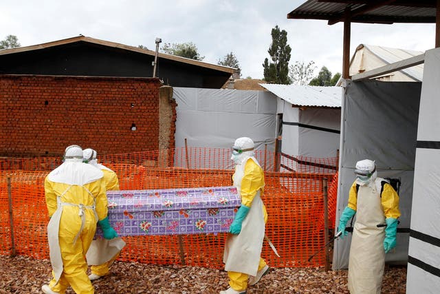 Health workers at a treatment centre in Butembo, DRC, carry the coffin of Kahambu Tulirwaho, who died of Ebola