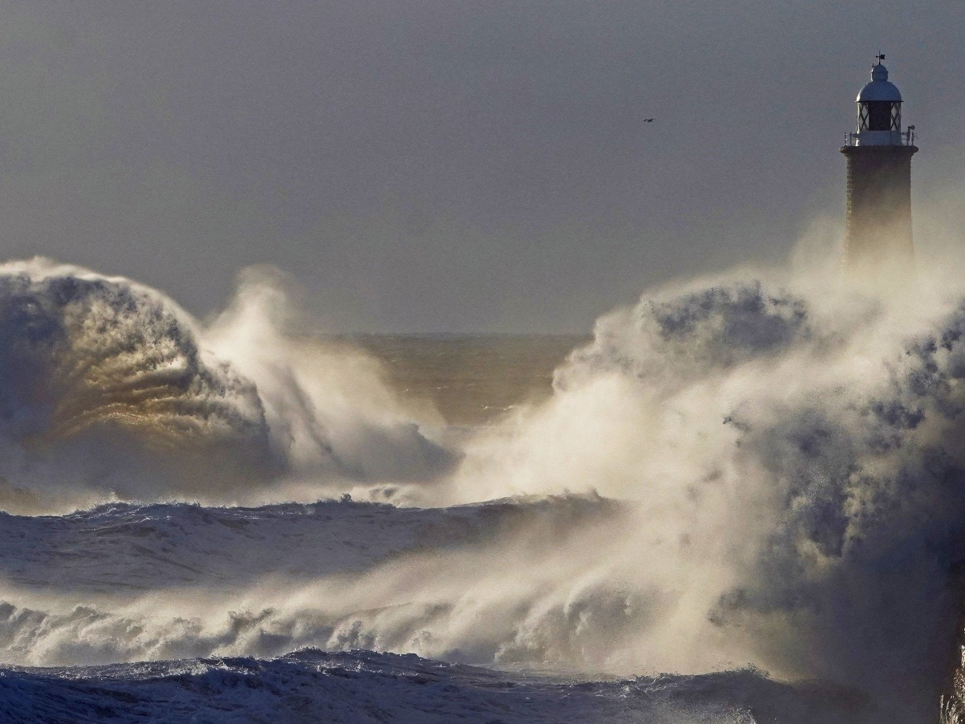 Waves crash over the sea wall at Tynemouth in the northeast of England in stormy weather two days before the bank holiday