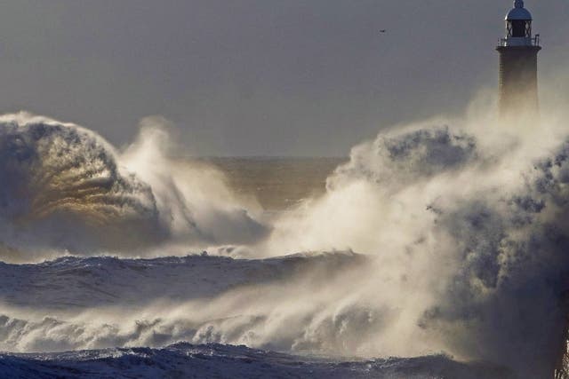 Waves crash over the sea wall at Tynemouth in the northeast of England in stormy weather two days before the bank holiday