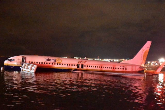 A Miami Air, Boeing 737 aircraft from Naval Station Guantanamo Bay, Cuba, sits in shallow water of the St Johns River after it slid off the runway