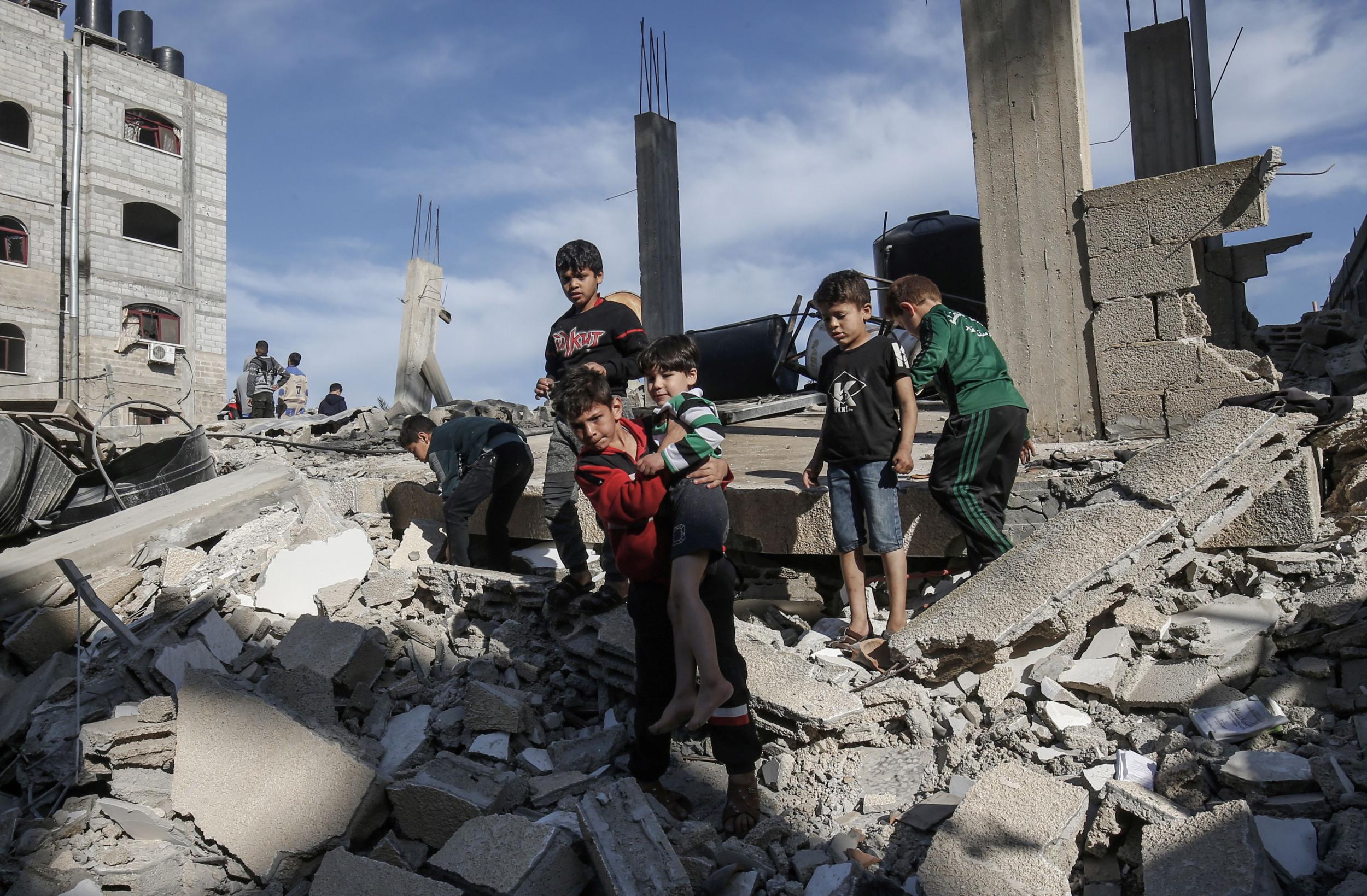 Palestinian children stand atop the remains of a building destroyed during an Israeli air strike on Rafah in the southern Gaza strip on Sunday (Said Khatib/AFP/Getty Images)