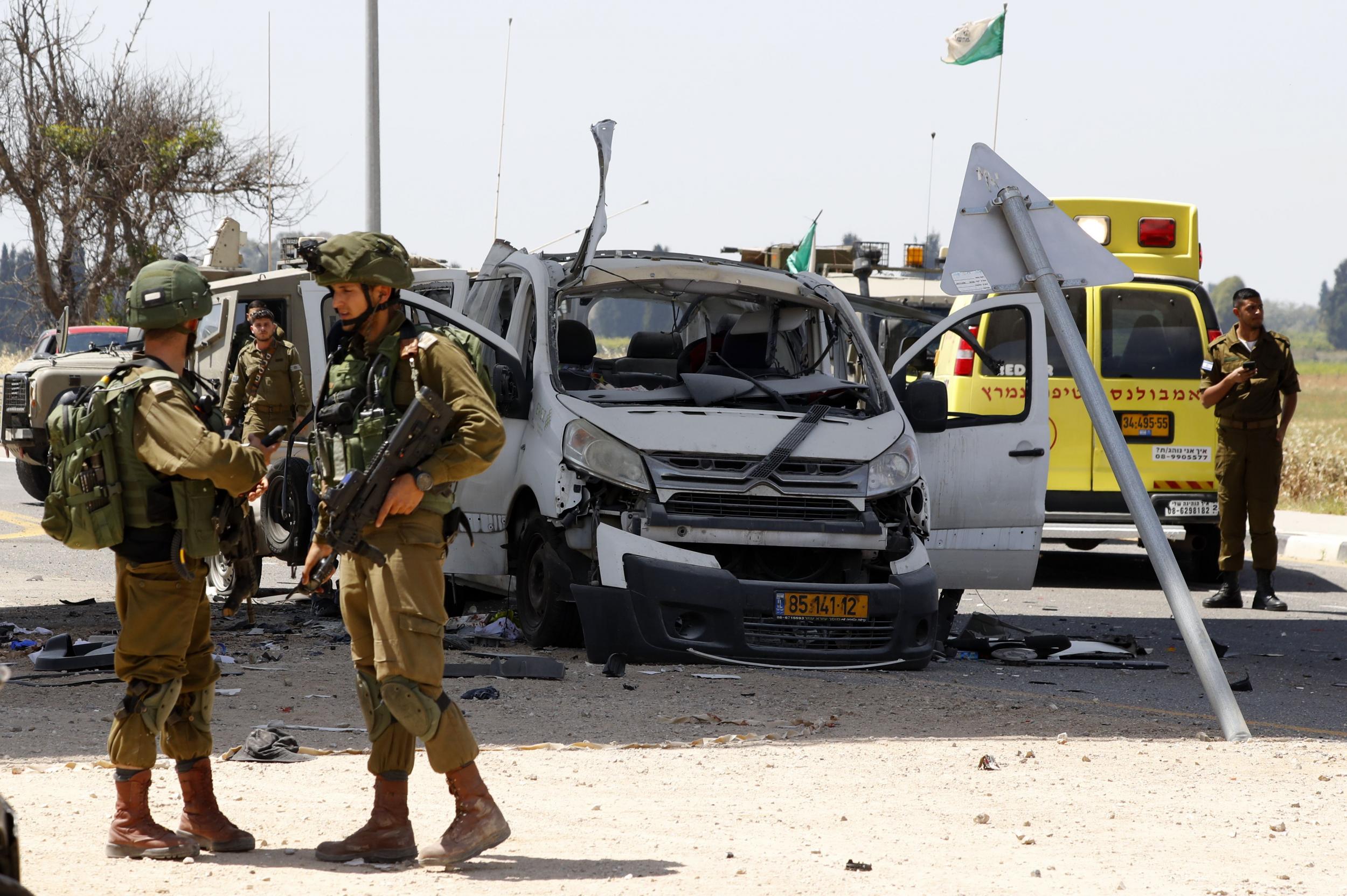 Israeli soldiers gather near a car that was hit by a rocket fired near Yad Mordechai on Sunday, reportedly injuring its driver (Jack Guez/AFP/Getty Images)