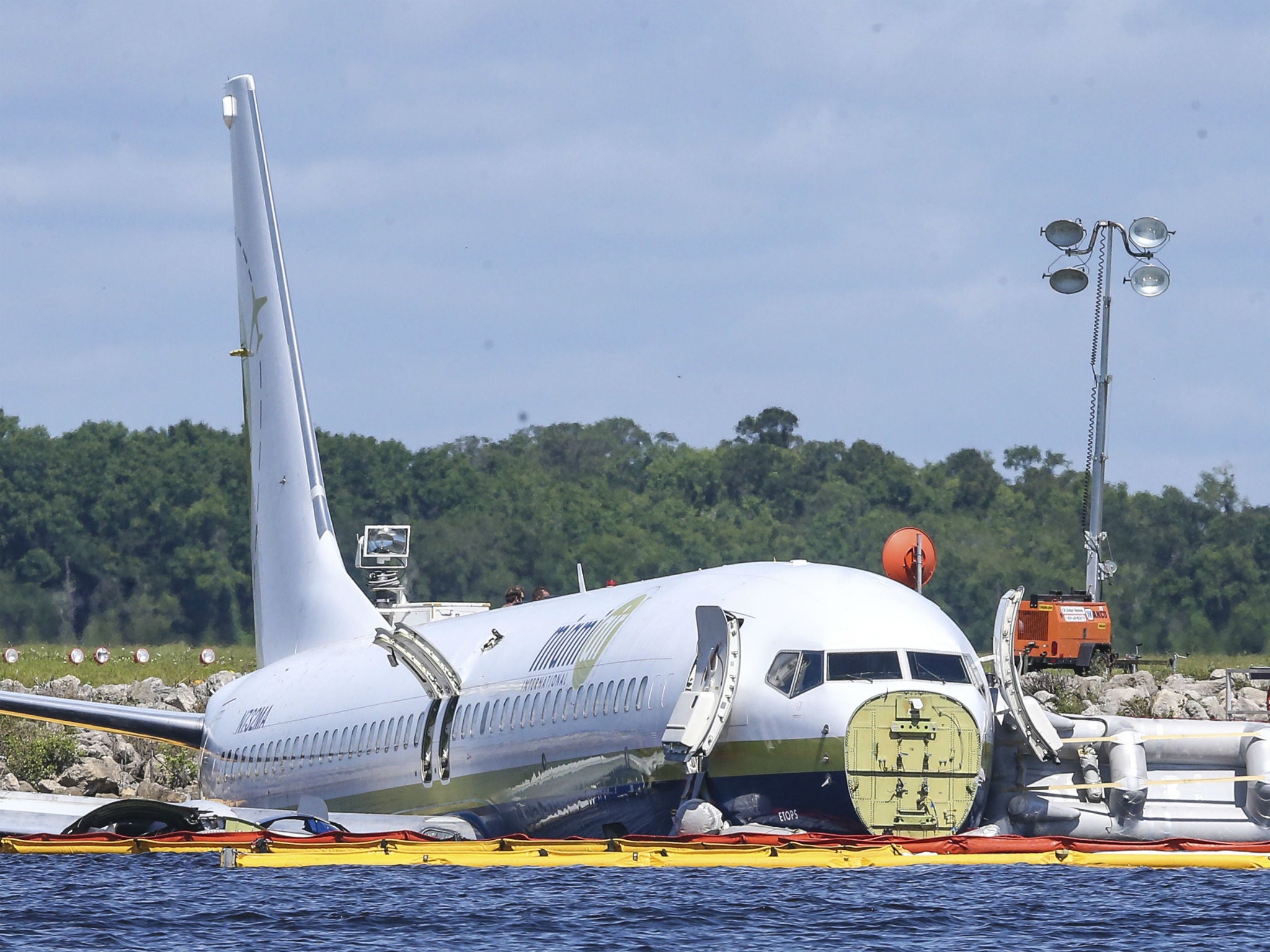 A charter plane carrying 143 people and traveling from Cuba to north Florida sits in a river at the end of a runway