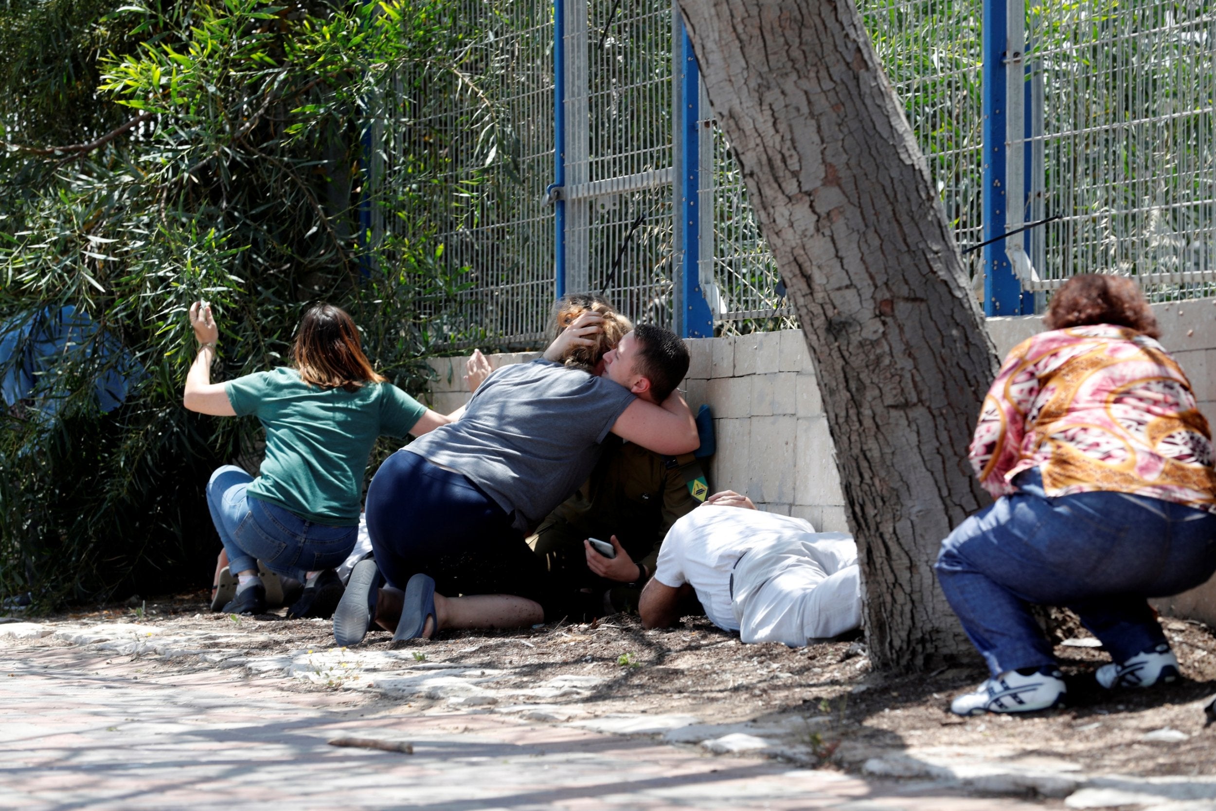 Israelis take cover as they hear sirens warning of incoming rockets from Gaza (Reuters)