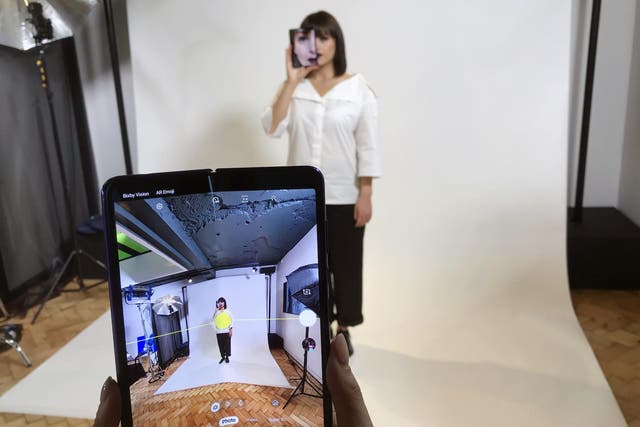 A model holds a Samsung Galaxy Fold smart phone to her face, during a media preview event in London