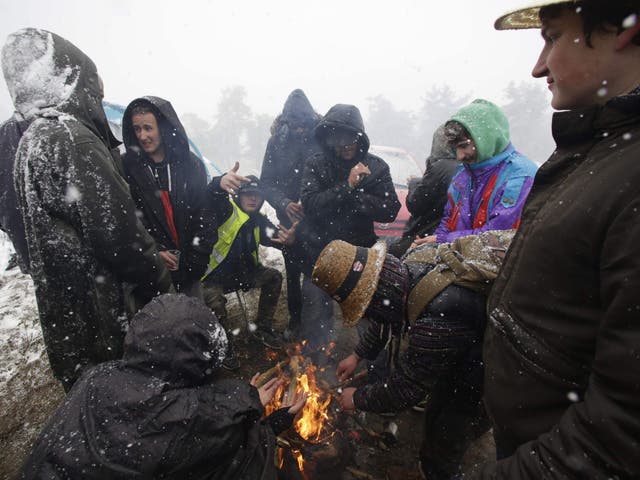 Festival-goers at Teknival make a bonfire as snow falls