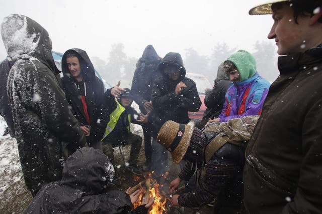 Festival-goers at Teknival make a bonfire as snow falls