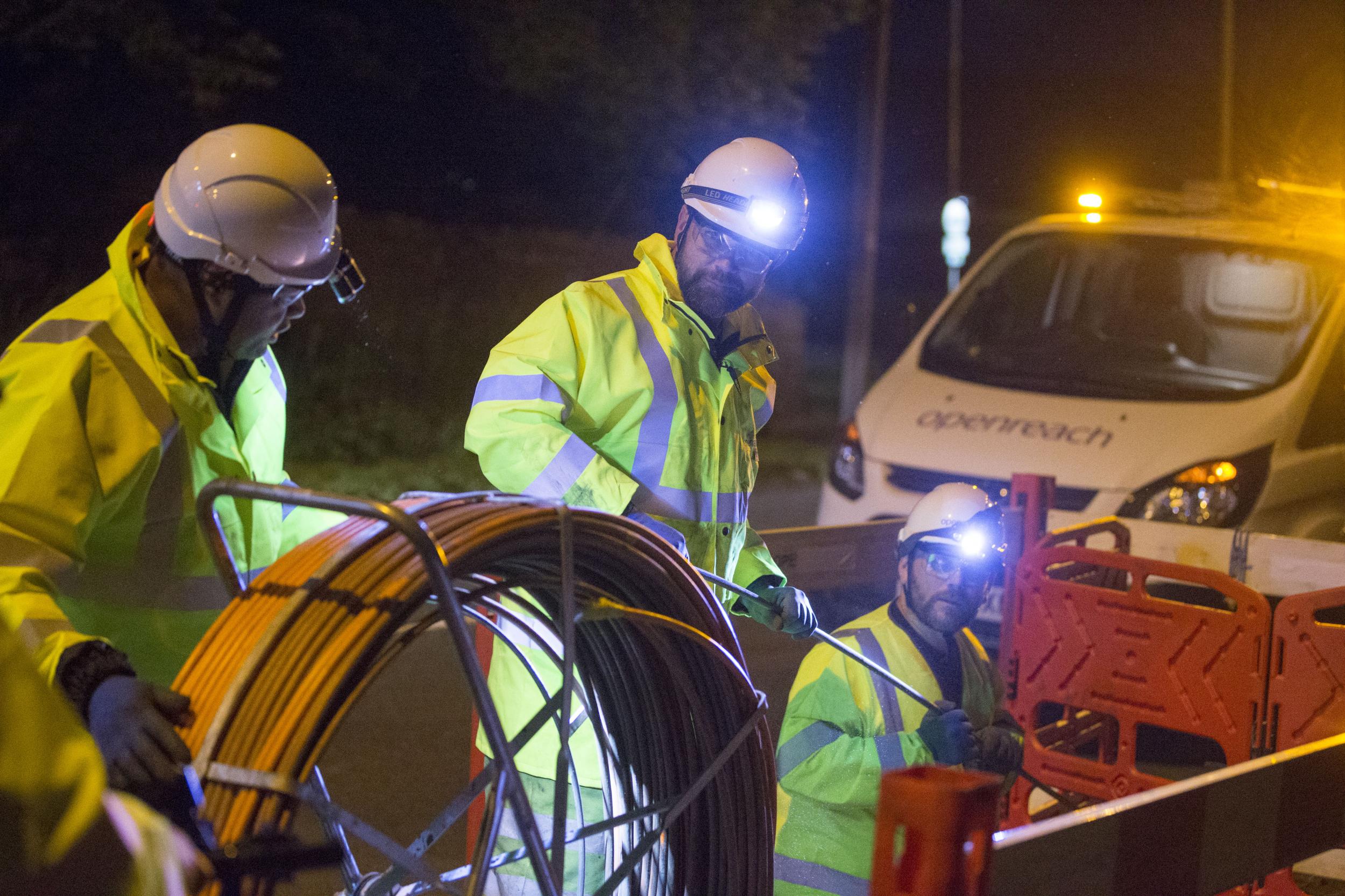 Cabling up under floodlights: BT has promised to speed up fibre broadband connections while maintaining its dividend