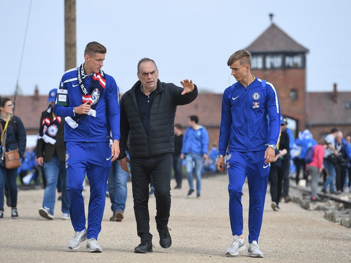 Avram Grant walks with two of Chelsea's academy players at Auschwitz