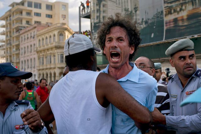 Plainclothes security officials and police detain an activist at the march in Havana