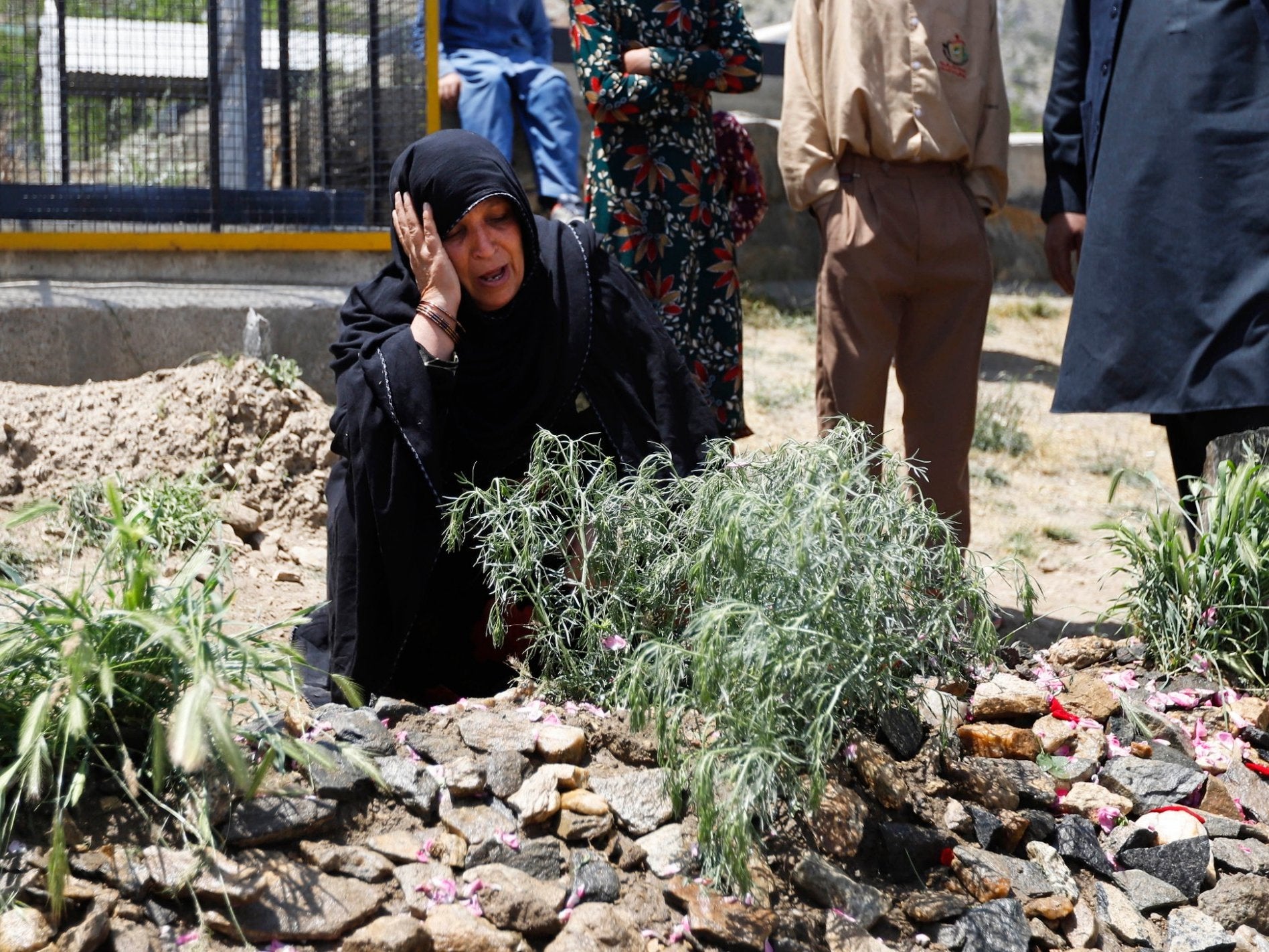 Mother of late Afghan female journalist and political adviser Mena Mangal grieves on her grave