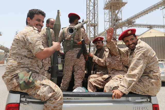 Houthi rebels ride in the back of a vehicle during their withdrawal from Saleef port in Hodeidah