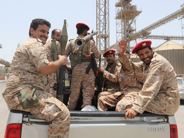 Houthi rebels ride in the back of a vehicle during their withdrawal from Saleef port in Hodeidah