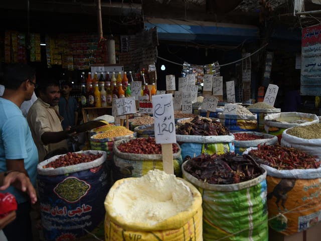 Pakistani customers buy grocery items at a market in Karachi on 10 May 2019. A government report has predicted that the country's growth rate was set to hit an eight-year low, leading to its 22nd bailout from the IMF.