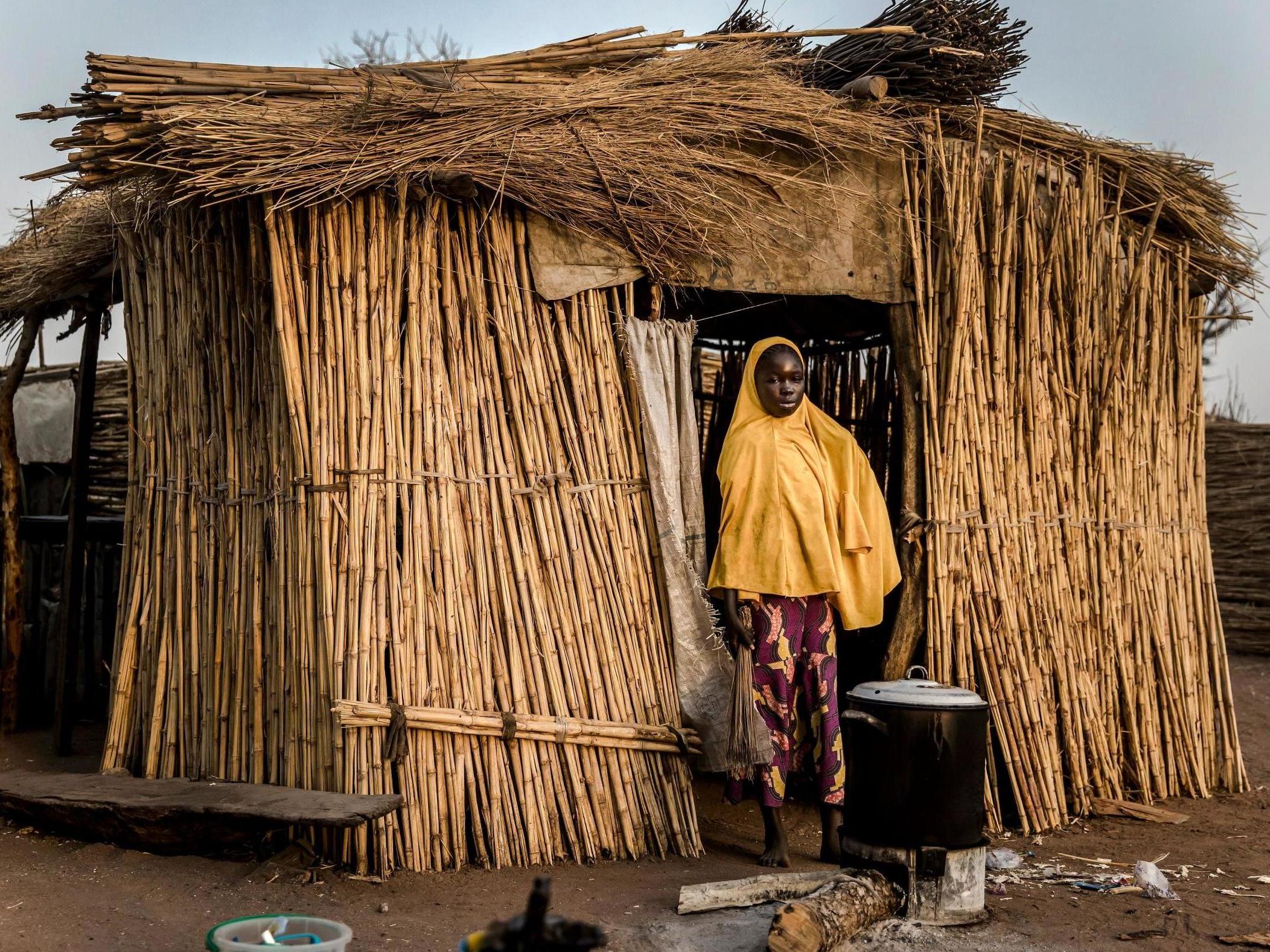A girl cooks in front of her house at Malkohi refugee camp in Jimeta, Adamawa State, Nigeria on February 19, 2019.