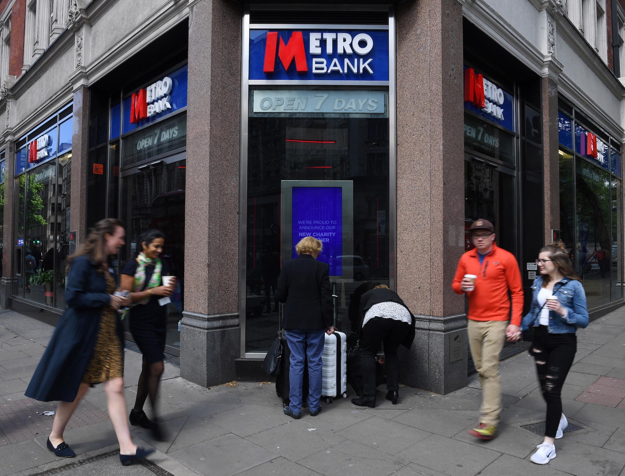 Pedestrians pass a Metro Bank in London, Britain