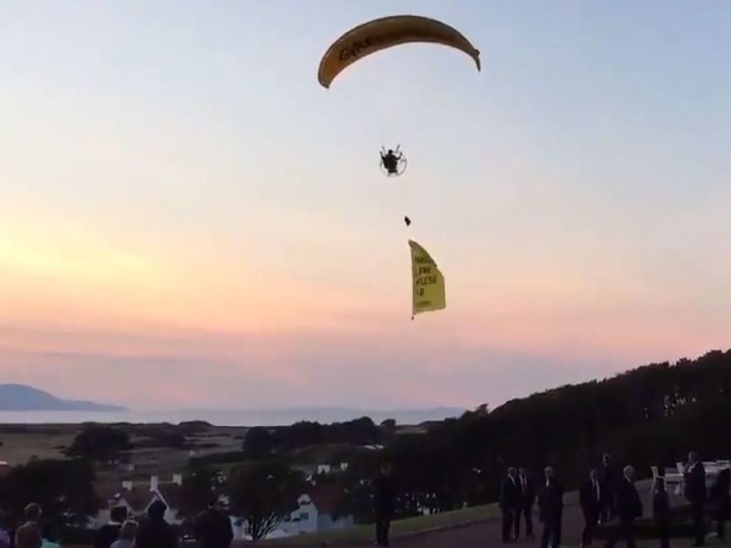 The paraglider trailed a banner reading 'Trump well below par'