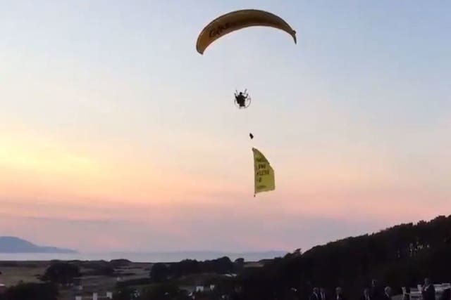 The paraglider trailed a banner reading 'Trump well below par'