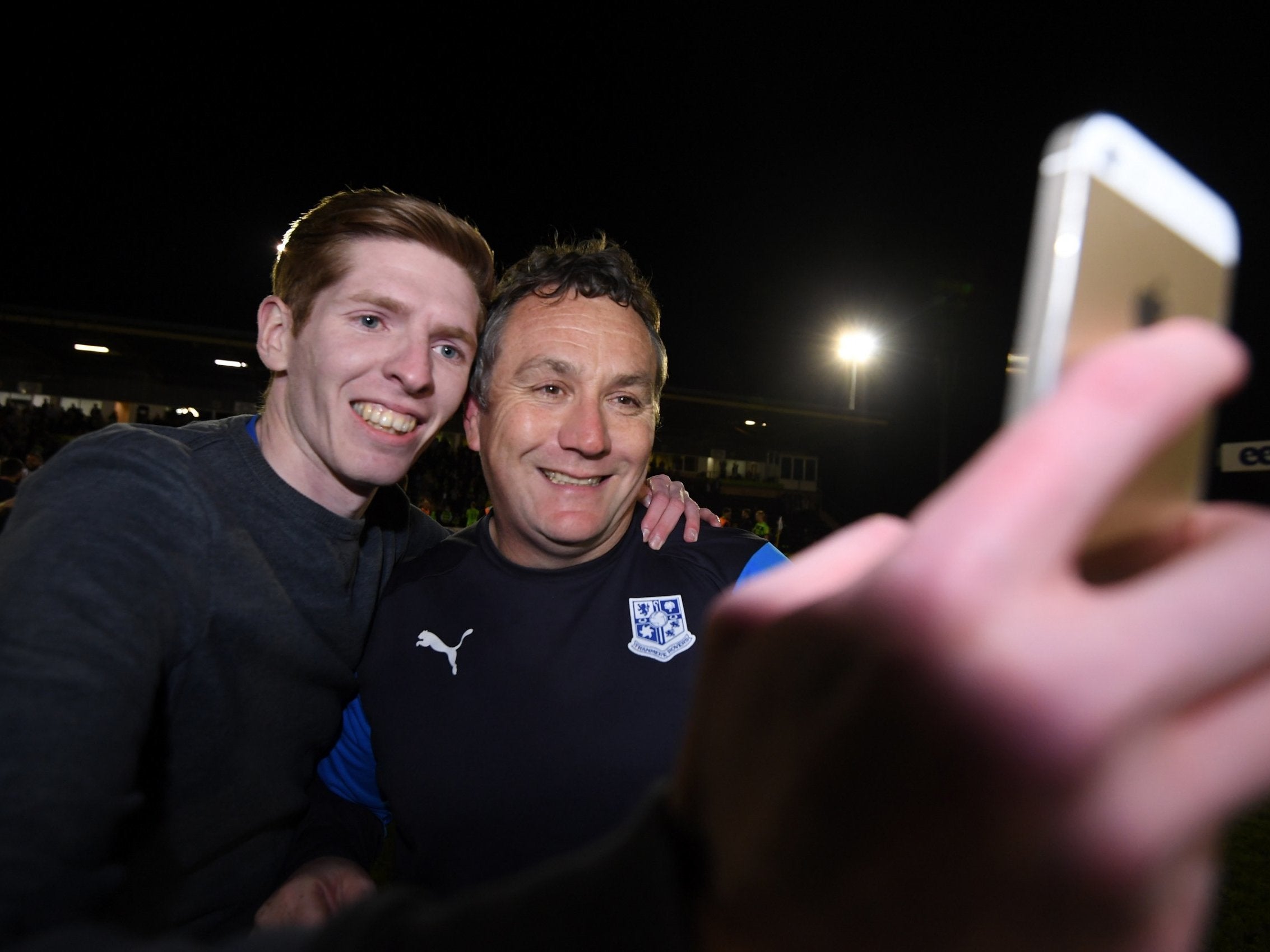 A Tranmere Rovers fan poses for a selfie with Tranmere manager Micky Mellon