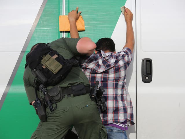 A US Border Patrol agent searches an immigrant from Central America while taking him into custody near Roma, Texas
