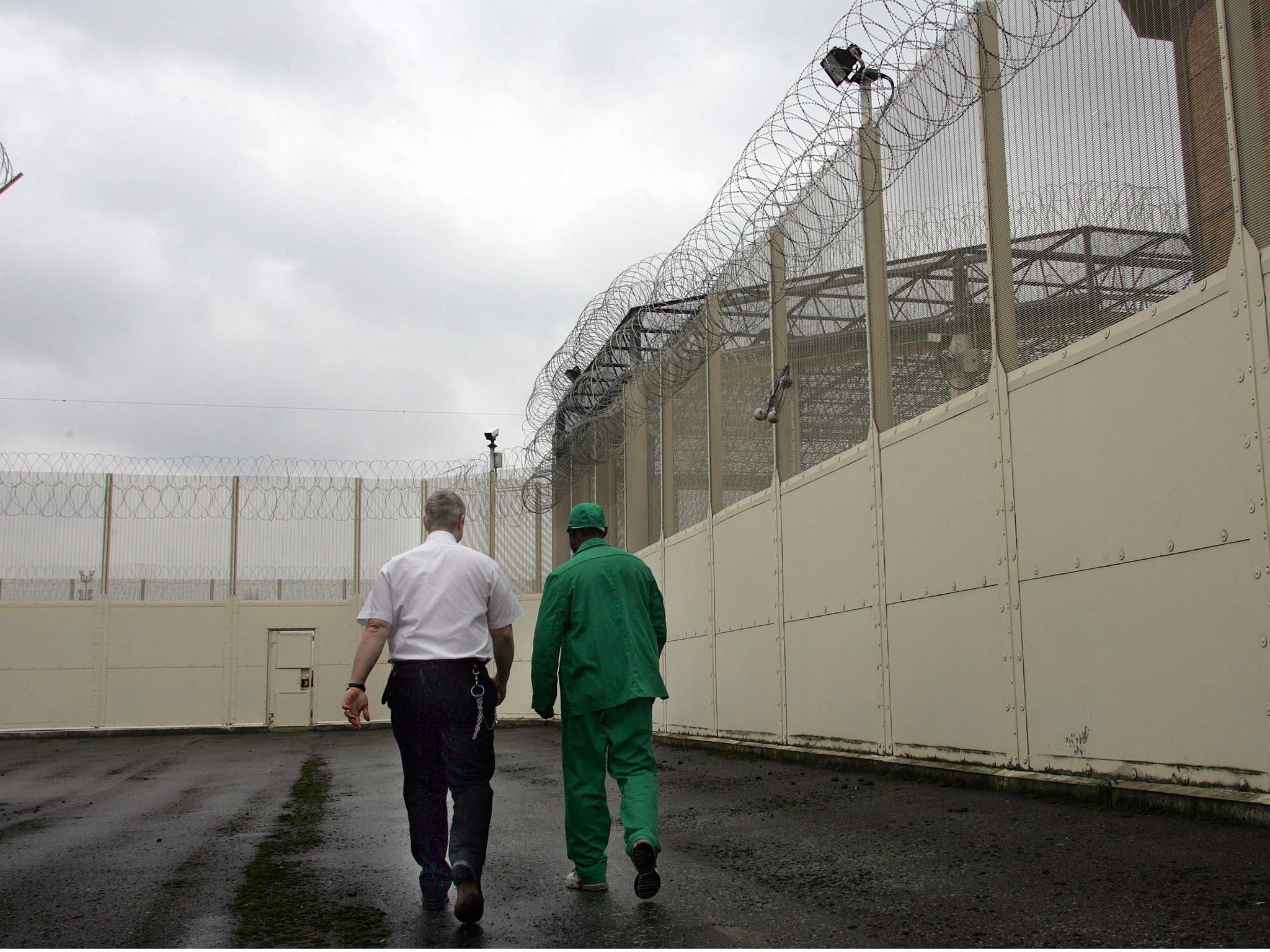 A prison officer and doctor walk between wings at HMP Belmarsh