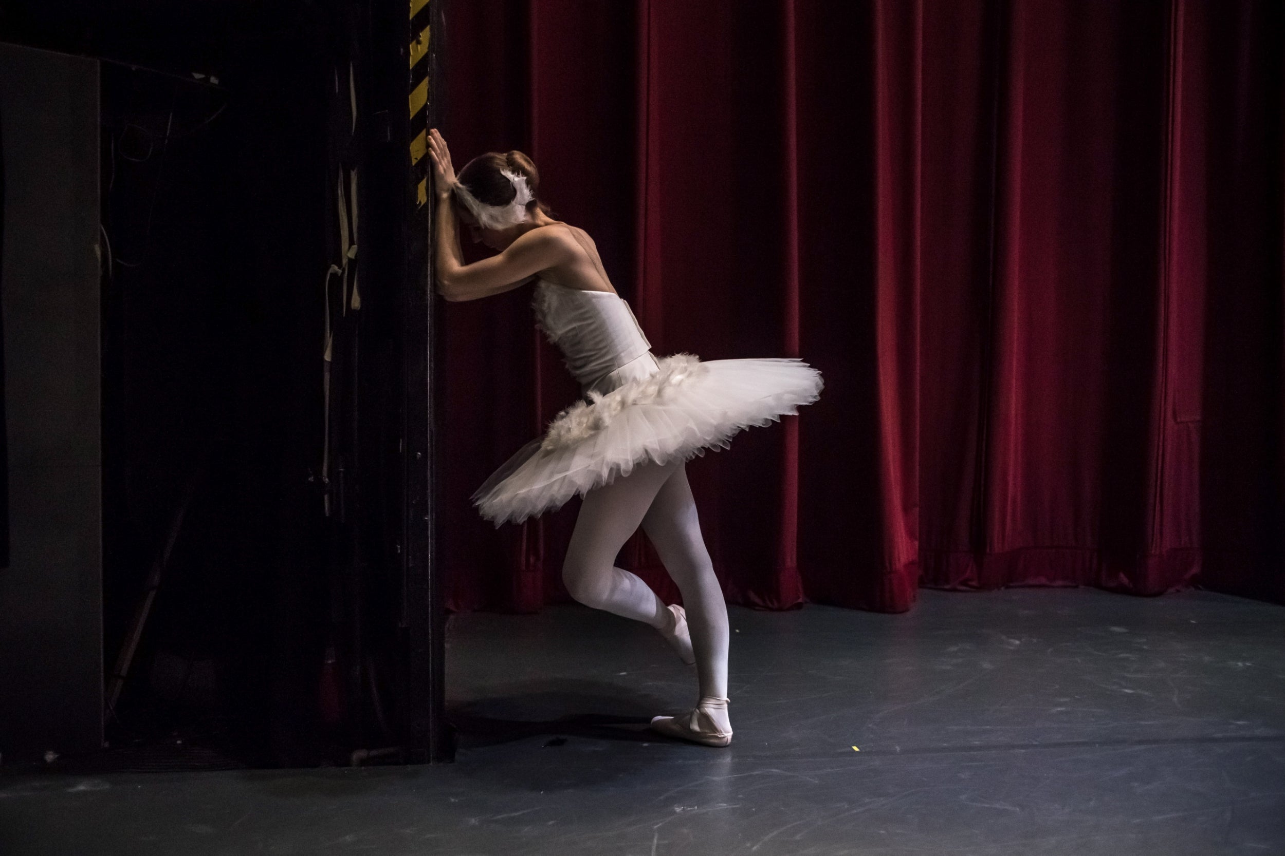 A dancer of the Czech National Ballet concentrates in front of a closed curtain during the second rehearsal of 'Swan Lake' at the National Theatre in Prague. Swan Lake ballet is one of the famous of all classical ballets
