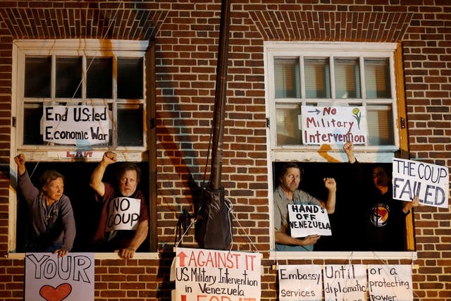 Supporters of Venezuelan President Nicolas Maduro are seen at the window of the Venezuelan embassy after federal agents attempted to evict and arrest four Maduro supporters to end their multi-week occupation, in Washington, US, 13 May 2019.
