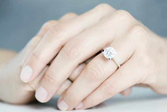 Diamond engagement ring on hands.