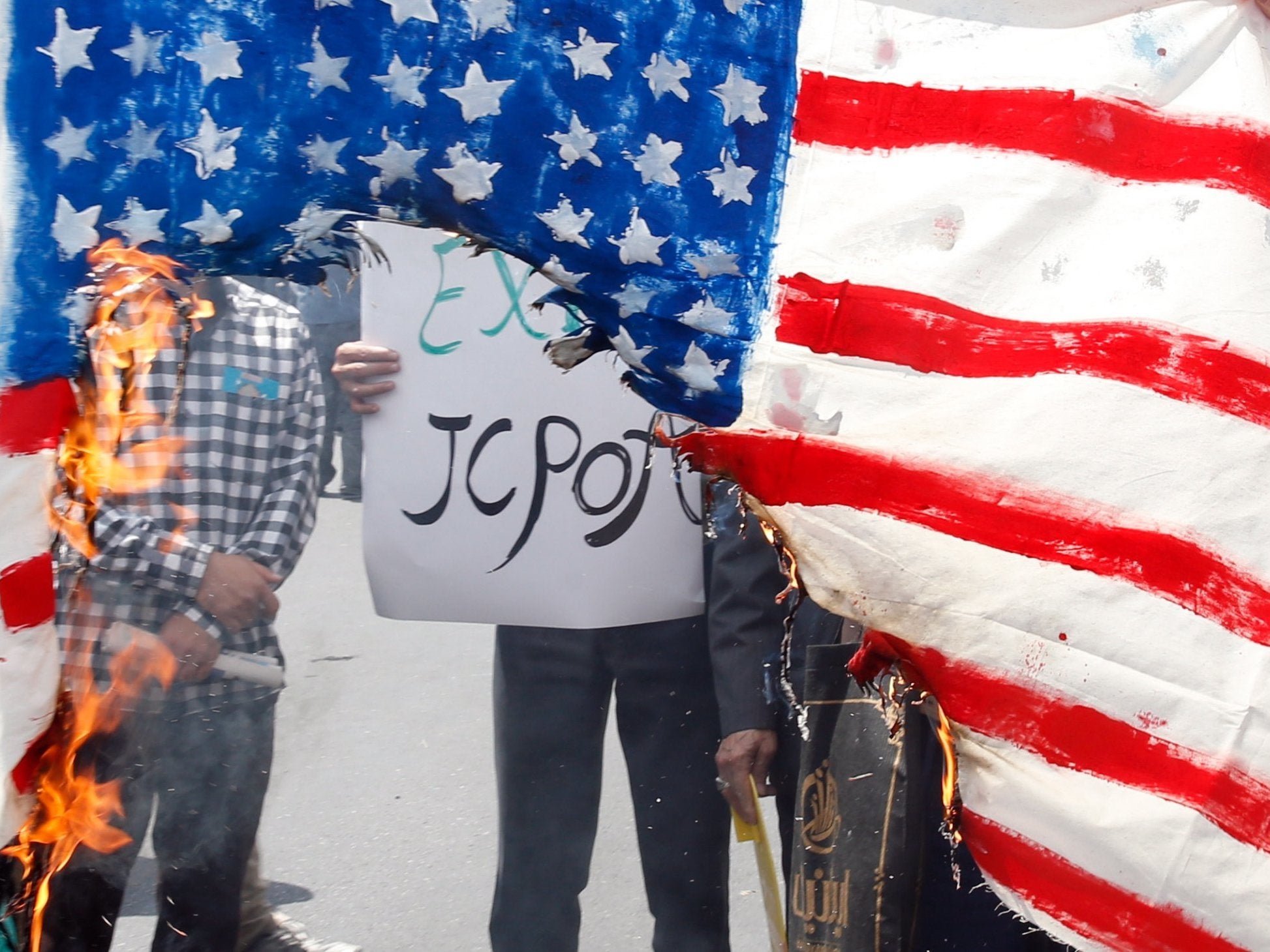 Demonstrators burn a US flag during an anti-US rally, to show their support of Iran's decision to pull out from some part of nuclear deal, in Tehran, Iran