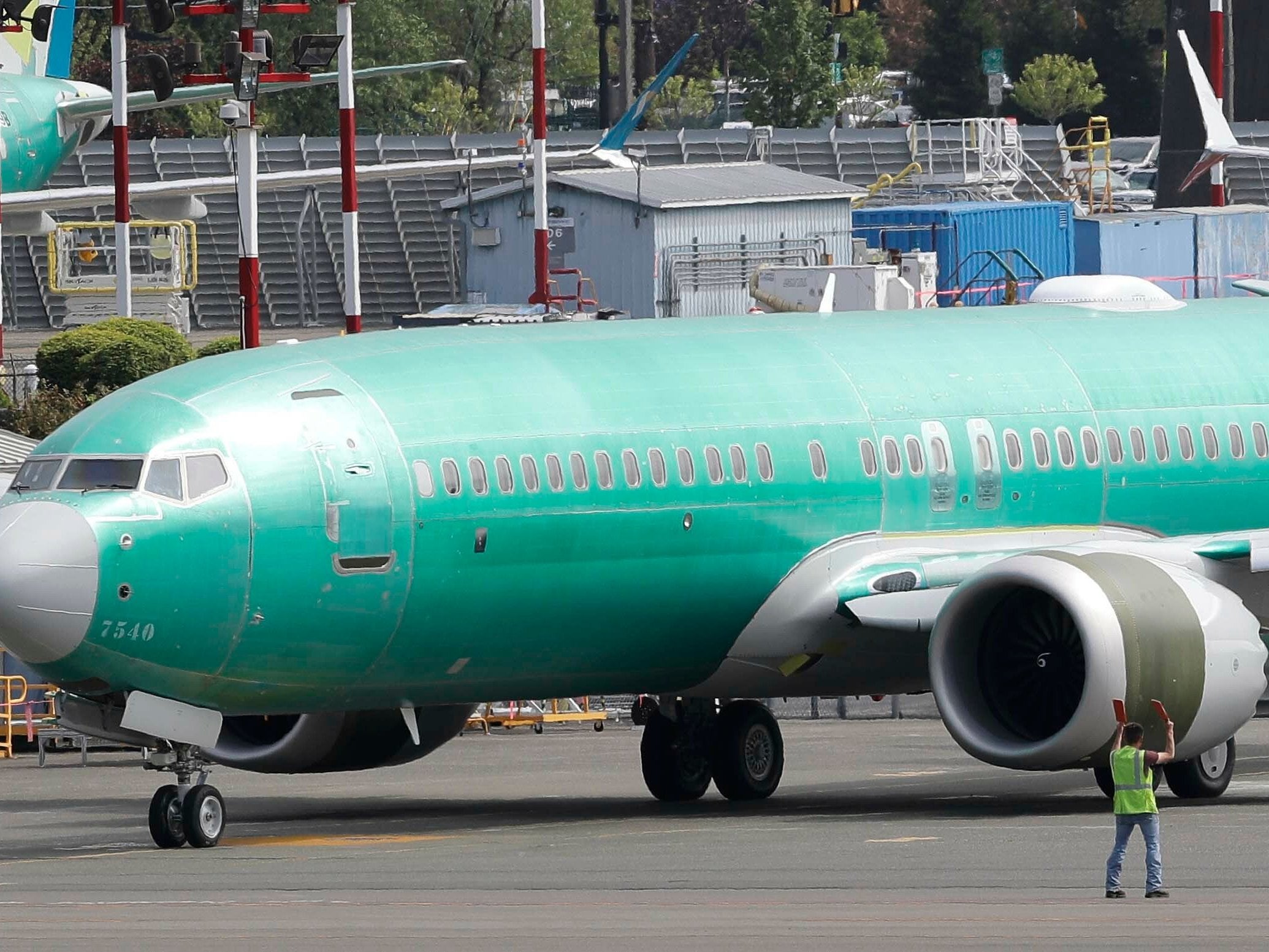 A worker stands near a Boeing 737 MAX 8 jetliner being built for American Airlines prior to a test flight, Wednesday, May 8, 2019, in Renton, Wash. Passenger flights using the plane remain grounded worldwide as investigations into two fatal crashes involving the airplane continue.
