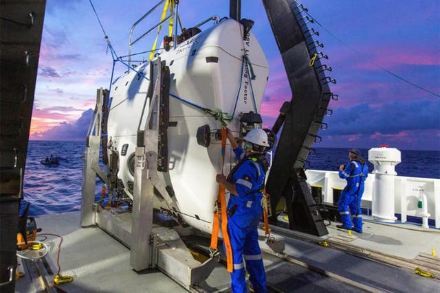Technicians prepare part of the submarine before its Pacific voyage