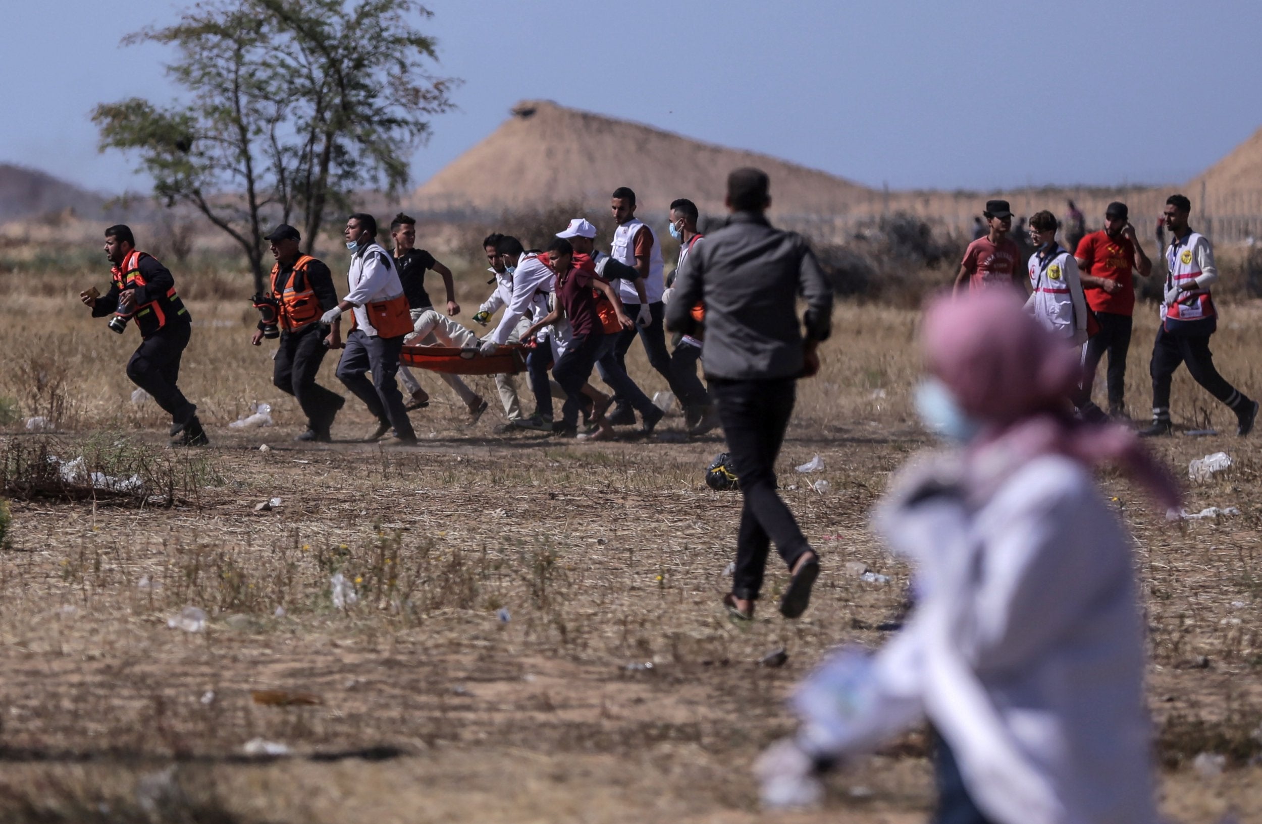 Palestinians carry a wounded youth during the clashes near the border between Israel and the eastern Gaza Strip, 15 May 2019