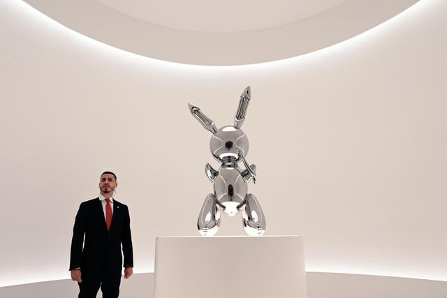 A security guard stands near Rabbit, a sculpture by US artist Jeff Koons