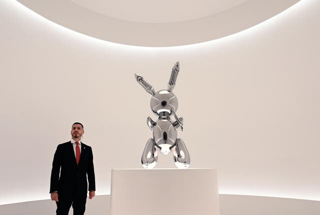 A security guard stands near Rabbit, a sculpture by US artist Jeff Koons