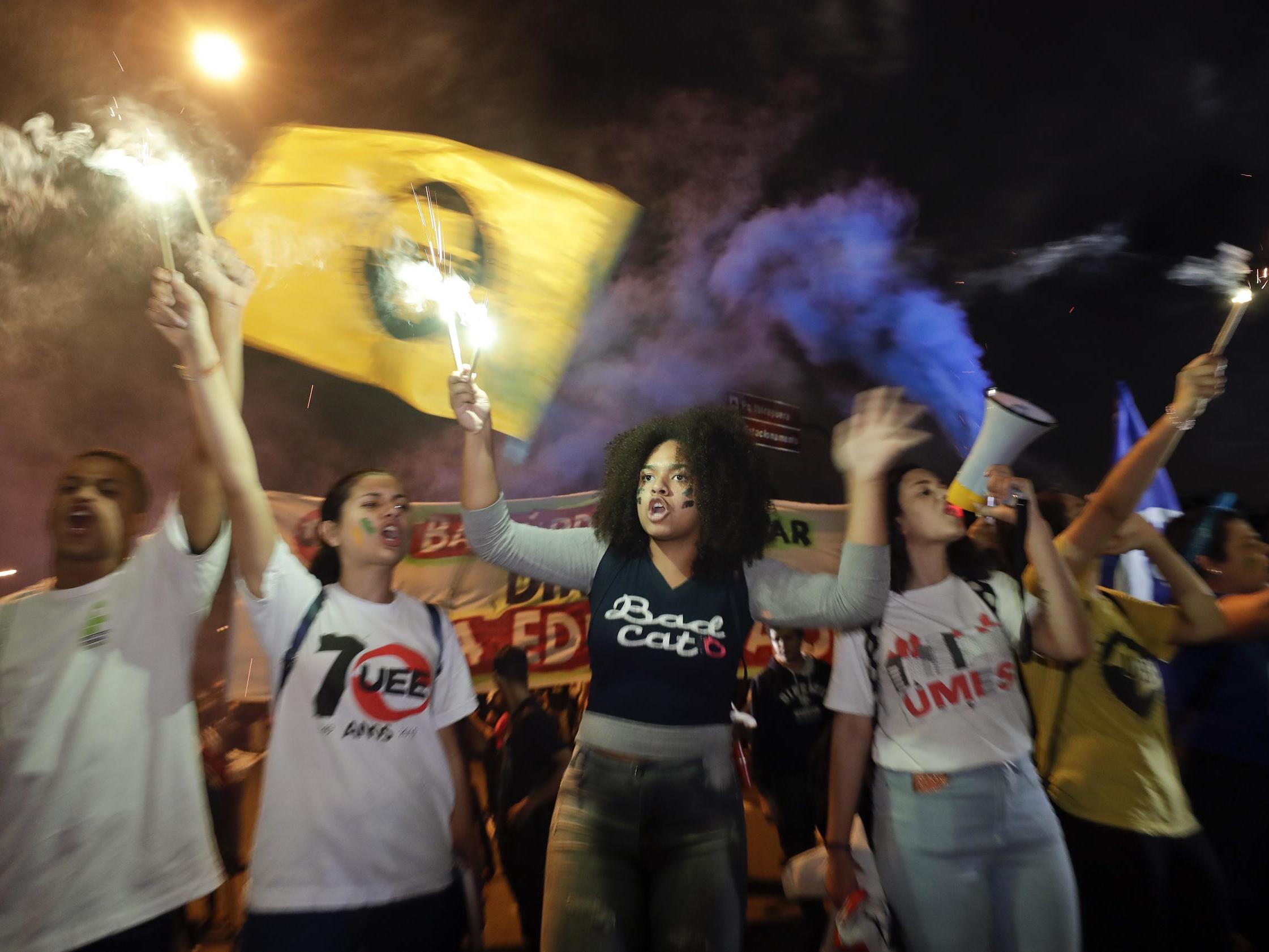 Students light flares during a protest in Sao Paulo