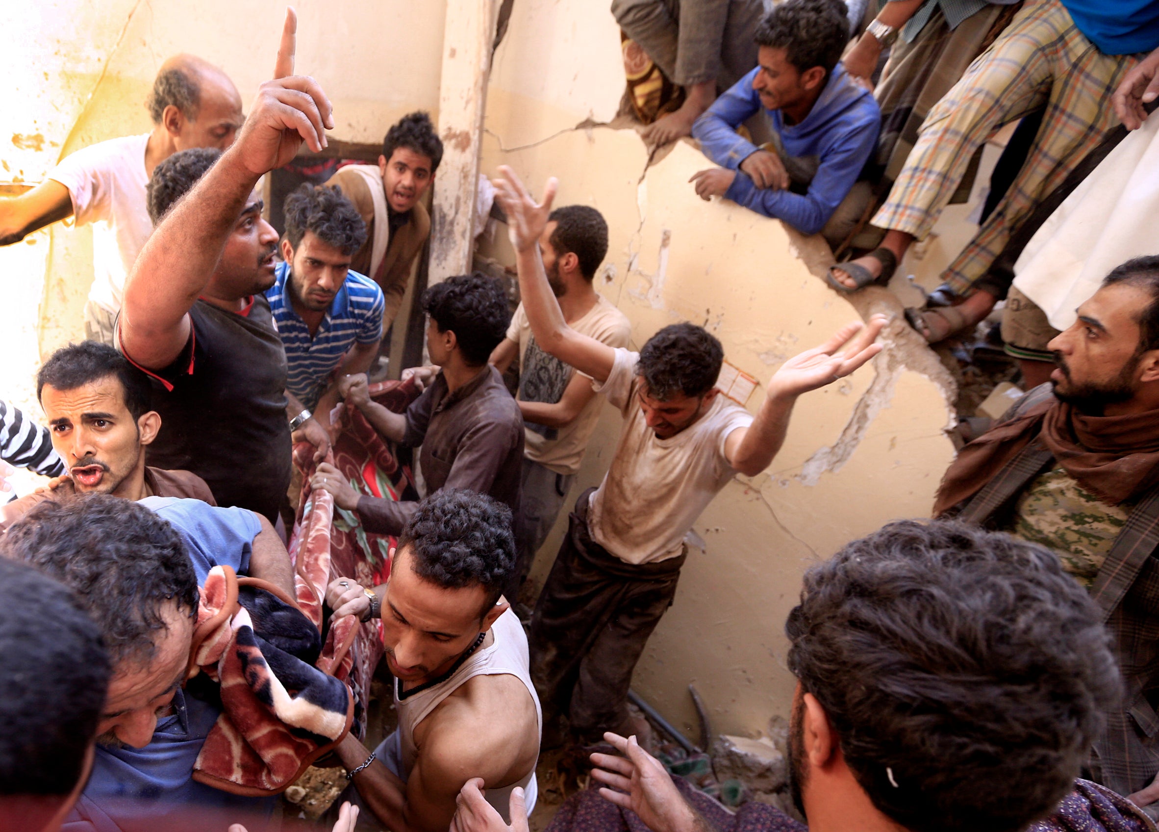 Yemenis carry a body recovered in the rubble of a destroyed building following reported Saudi-led coalition airstrikes in the Yemeni capital Sana’a (Mohammed Huwais/AFP/Getty)